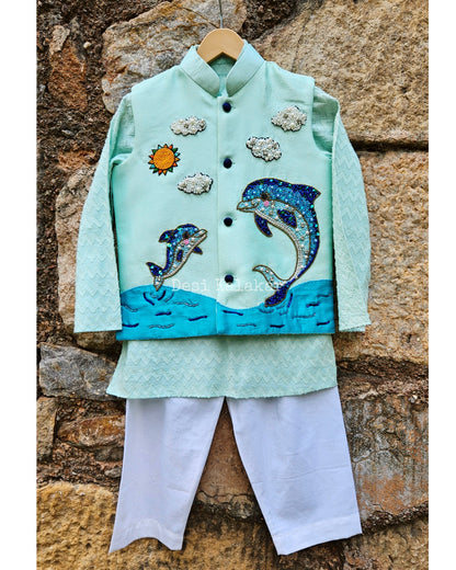 "Three-piece boys' festive outfit featuring a sea green hand-embroidered dolphin jacket layered over a matching textured zig-zag kurta and classic white pants."