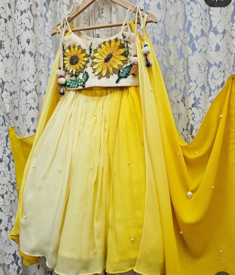 Sunshine yellow handcrafted sunflower motif blouse and pearl-accented flared lehenga set for girls by Desi Kalakar.