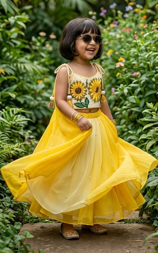 Sunshine yellow handcrafted sunflower motif blouse and pearl-accented flared lehenga set for girls by Desi Kalakar.